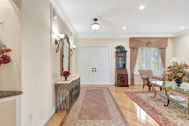 foyer featuring light wood-style floors, crown molding, recessed lighting, and baseboards