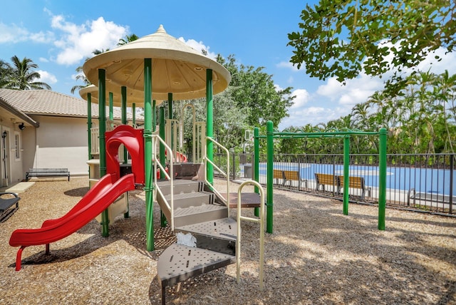 community jungle gym featuring fence and a water view