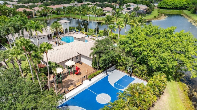 aerial view of a nearby body of water, a pool, and a tree filled landscape
