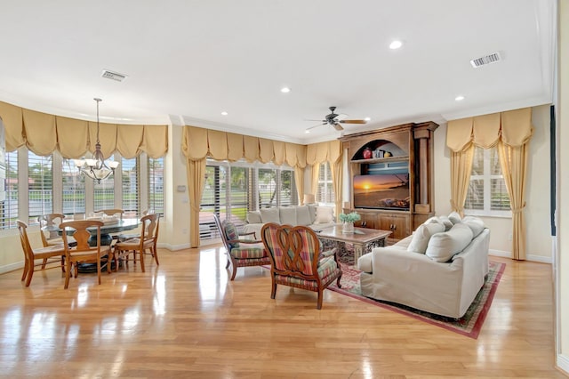 living room featuring baseboards, a chandelier, light wood-type flooring, ceiling fan, and ornamental molding