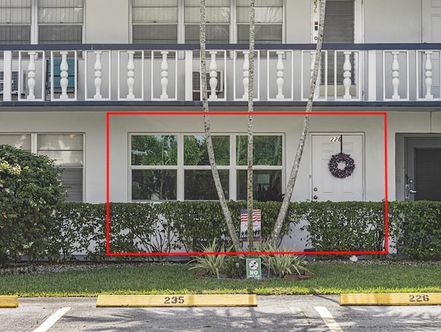226 Northampton L Unit 226, West Palm Beach, FL 33417 - view of exterior entry with a balcony and uncovered parking