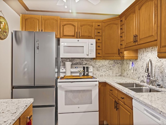 226 Northampton L Unit 226, West Palm Beach, FL 33417 - kitchen with white appliances, a sink, tasteful backsplash, light stone countertops, and brown cabinets