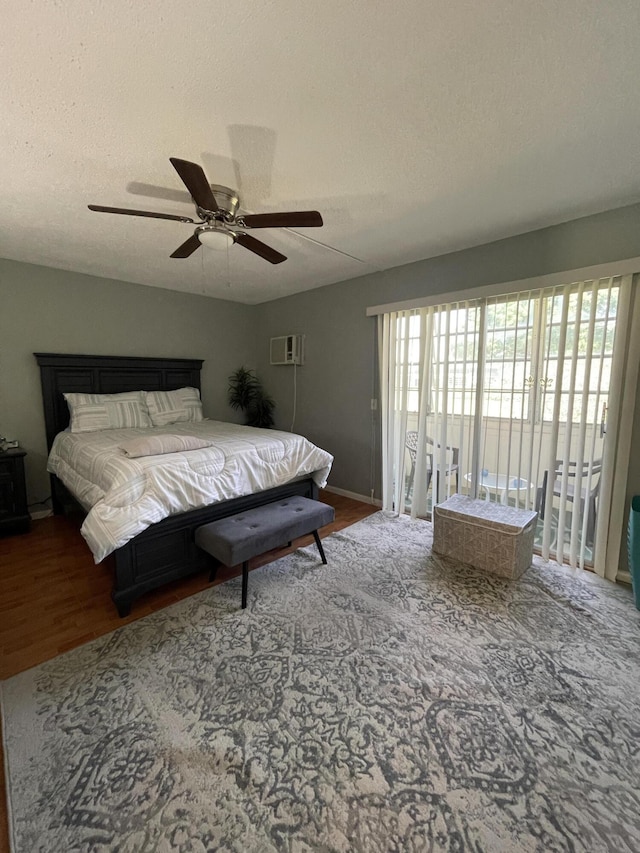 196 Upminster L Unit 196, Deerfield Beach, FL 33442 - bedroom with access to exterior, wood finished floors, a wall mounted air conditioner, a textured ceiling, and ceiling fan