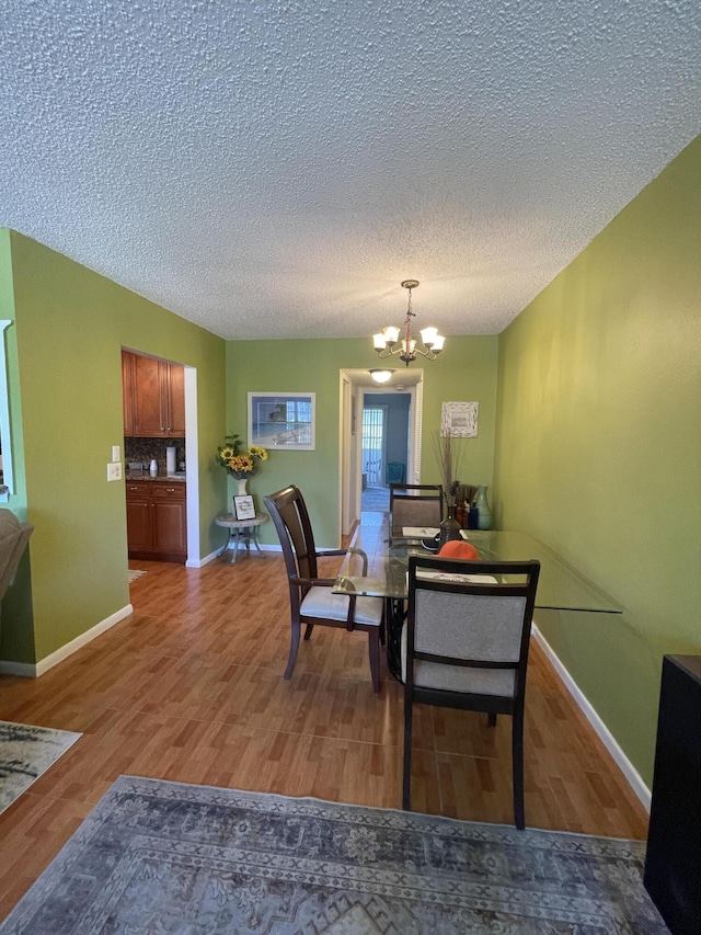 196 Upminster L Unit 196, Deerfield Beach, FL 33442 - dining area with a chandelier, a textured ceiling, light wood-style floors, and baseboards