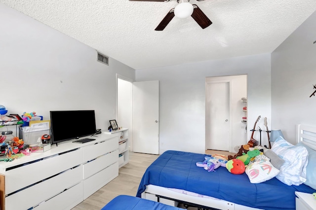 1124 NW 13th St Unit 208, Boca Raton, FL 33486 - bedroom with light wood-type flooring, a textured ceiling, and ceiling fan