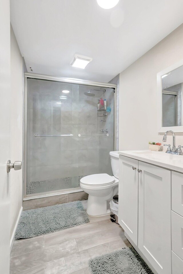 1124 NW 13th St Unit 208, Boca Raton, FL 33486 - bathroom with vanity, a stall shower, toilet, and wood finished floors