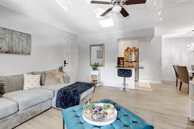 1124 NW 13th St Unit 208, Boca Raton, FL 33486 - living area with a ceiling fan, light wood-style flooring, a textured ceiling, a chandelier, and baseboards