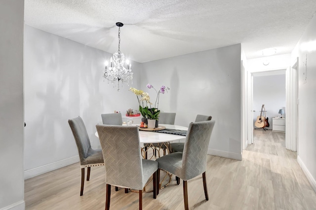 1124 NW 13th St Unit 208, Boca Raton, FL 33486 - dining area featuring light wood-style flooring, a chandelier, baseboards, and a textured ceiling