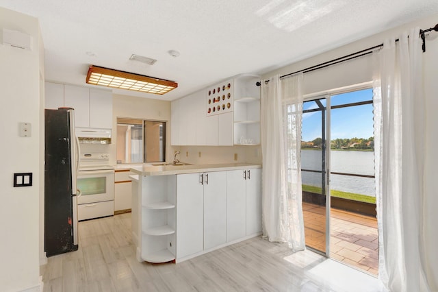1388 Garden Rd, Weston, FL 33326 - kitchen featuring open shelves, electric range, freestanding refrigerator, and white cabinets