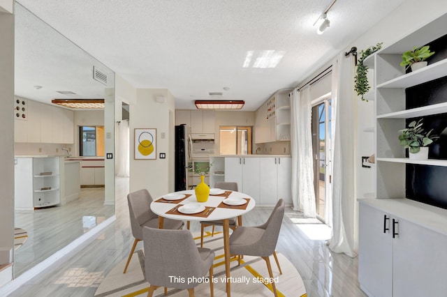 1388 Garden Rd, Weston, FL 33326 - dining area with a textured ceiling and light wood-style flooring