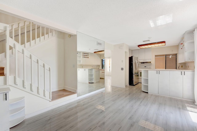 1388 Garden Rd, Weston, FL 33326 - unfurnished living room with light wood-style floors, stairway, and a textured ceiling