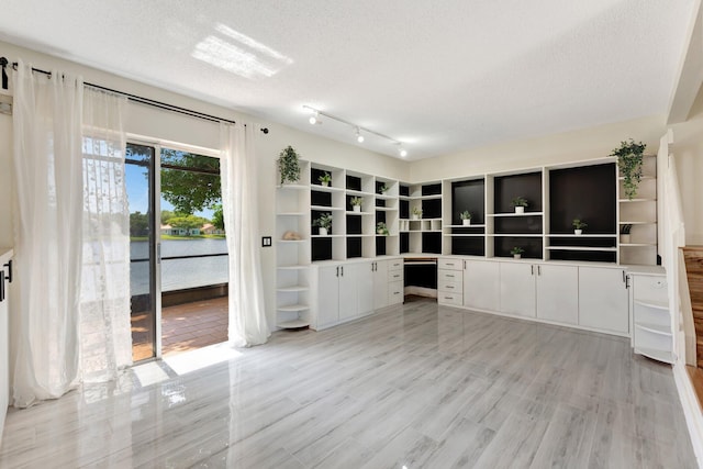 1388 Garden Rd, Weston, FL 33326 - empty room with built in study area, a textured ceiling, and a water view