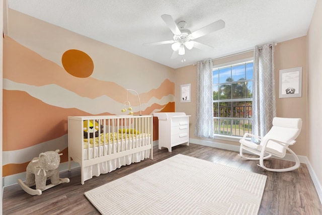1388 Garden Rd, Weston, FL 33326 - bedroom featuring wood finished floors, a textured ceiling, a ceiling fan, and a crib