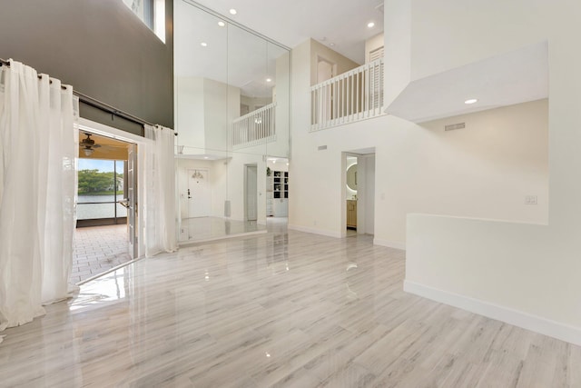 1388 Garden Rd, Weston, FL 33326 - unfurnished living room with a towering ceiling, light wood-style floors, ceiling fan, and recessed lighting