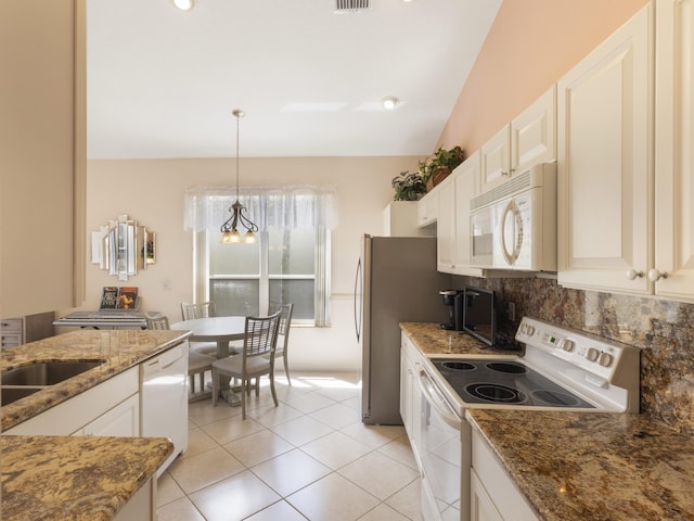 kitchen featuring white appliances, decorative backsplash, dark stone counters, a chandelier, and light tile patterned floors