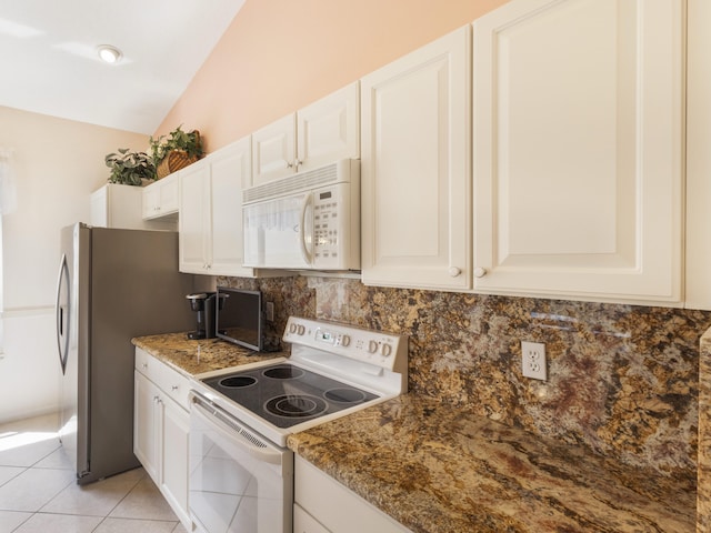 kitchen with white appliances, decorative backsplash, vaulted ceiling, white cabinetry, and light tile patterned floors