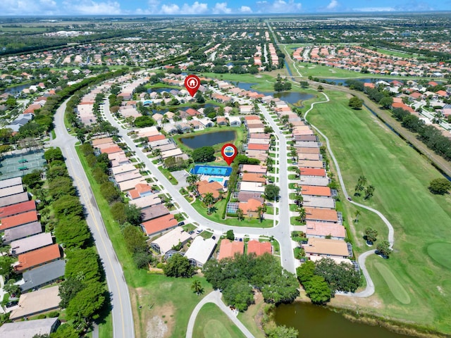 view of property location with a golf club, a nearby body of water, and nearby suburban area