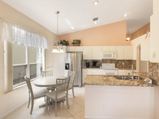 kitchen with white appliances, a sink, backsplash, a peninsula, and stone countertops
