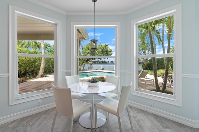 dining space with baseboards, light wood-style flooring, and crown molding