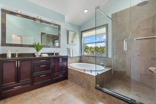bathroom with a bath, a stall shower, lofted ceiling, double vanity, and recessed lighting