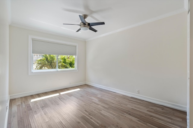 spare room featuring crown molding, a ceiling fan, baseboards, and wood finished floors