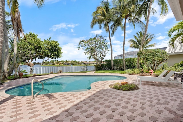 view of pool featuring a fenced backyard, a patio, and a water view