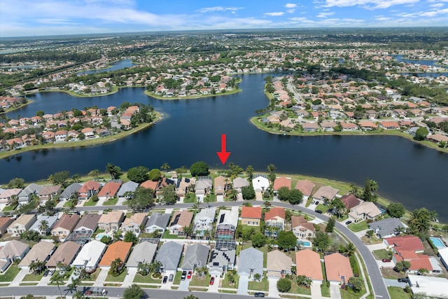aerial view of property and surrounding area with a nearby body of water and nearby suburban area