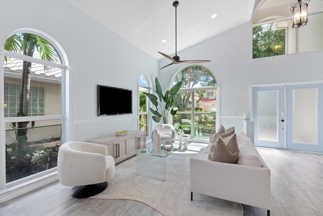 living area featuring light wood-type flooring, high vaulted ceiling, ceiling fan, and recessed lighting