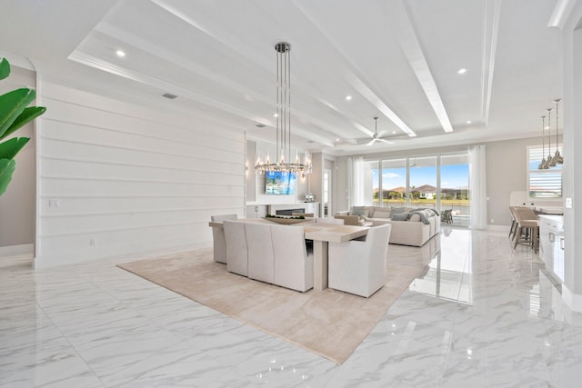 living area featuring a chandelier, light marble finish floors, a tray ceiling, recessed lighting, and a ceiling fan