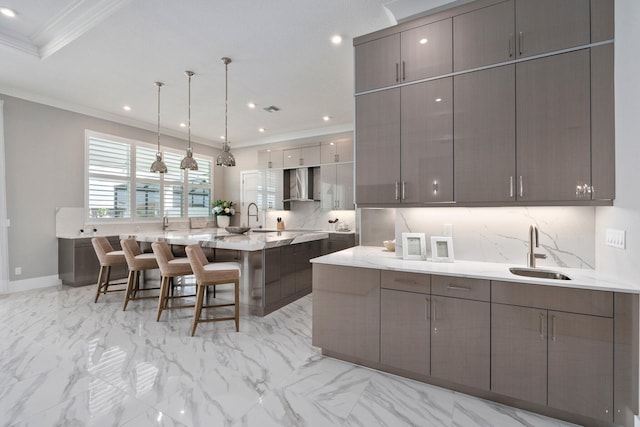 kitchen with a sink, modern cabinets, crown molding, decorative backsplash, and a breakfast bar