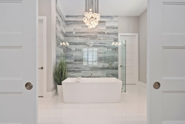 bathroom featuring tile patterned floors, a freestanding bath, a chandelier, baseboards, and a shower