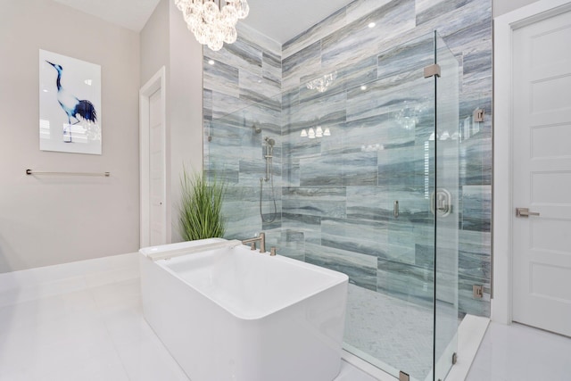 full bathroom featuring a chandelier, a shower stall, tile patterned flooring, and a freestanding tub