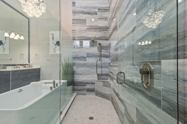 bathroom with a freestanding bath, a stall shower, double vanity, and a chandelier