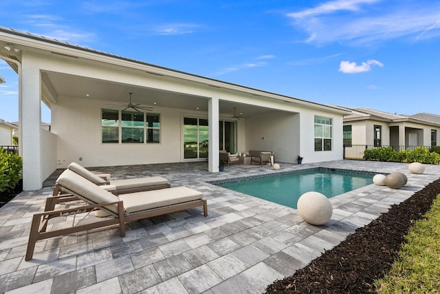 rear view of house featuring a ceiling fan, a patio area, stucco siding, an outdoor hangout area, and fence