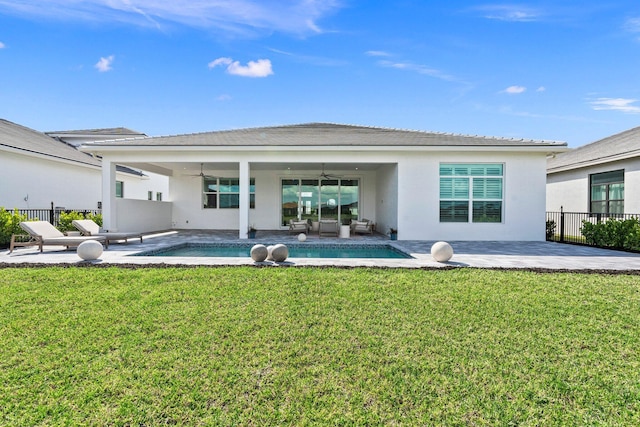 rear view of property featuring ceiling fan, a patio, outdoor lounge area, an outdoor pool, and stucco siding