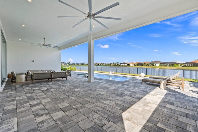 view of patio / terrace with ceiling fan, an outdoor living space, fence, a water view, and a residential view