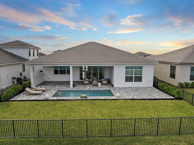 back of house at dusk with outdoor lounge area, stucco siding, a patio area, and a tiled roof