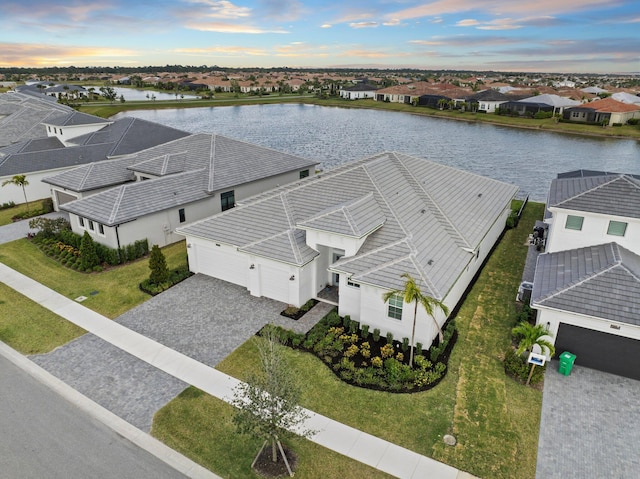 aerial view at dusk of a water view and a residential view