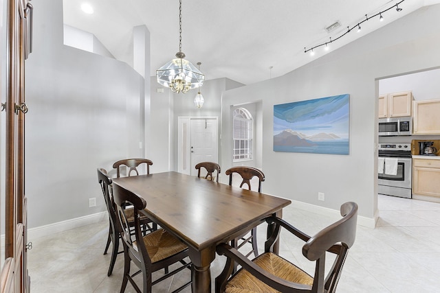 dining space featuring vaulted ceiling, a chandelier, light tile patterned floors, and baseboards