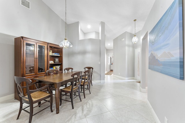 dining space featuring a chandelier, a high ceiling, baseboards, and light tile patterned flooring