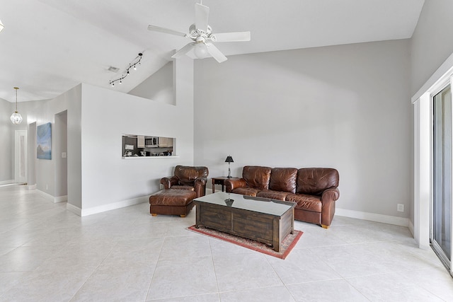 living area with ceiling fan, baseboards, light tile patterned floors, rail lighting, and high vaulted ceiling
