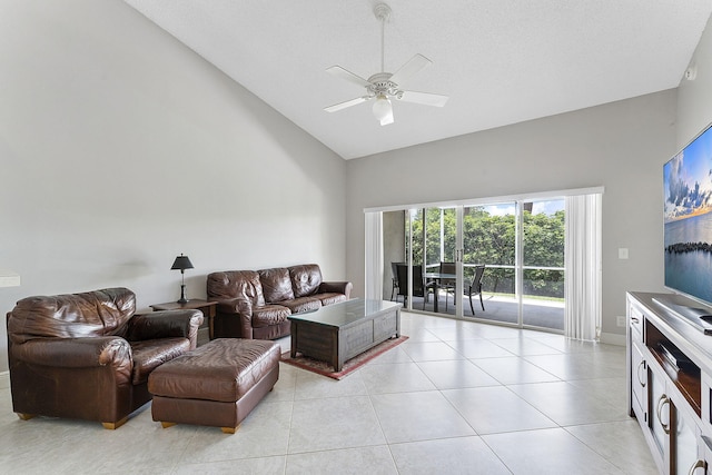 living room with high vaulted ceiling, ceiling fan, light tile patterned flooring, and baseboards