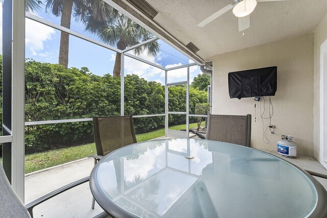 sunroom with a ceiling fan and outdoor dining area