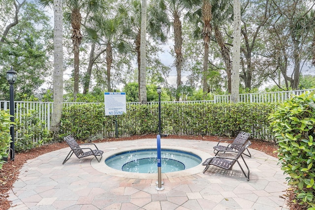 view of swimming pool with a hot tub and a fenced backyard