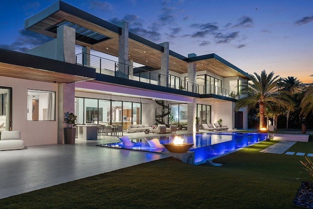 4460 NE 31st Ave, Lighthouse Point, FL 33064 - rear view of property featuring a balcony, outdoor lounge area, a patio, an infinity pool, and a yard