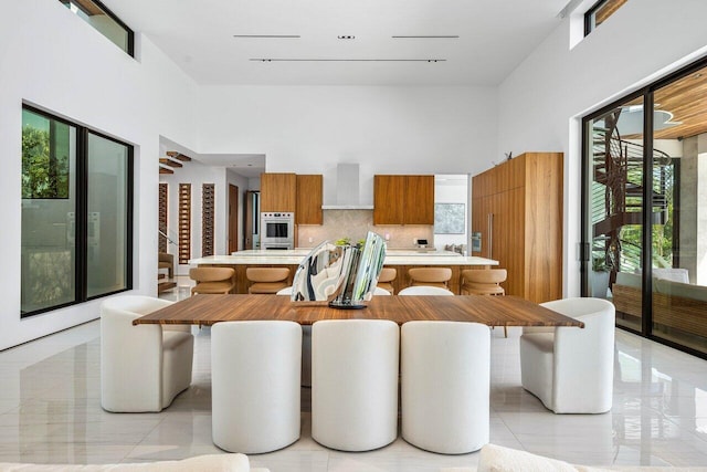4460 NE 31st Ave, Lighthouse Point, FL 33064 - dining space with plenty of natural light, a towering ceiling, and light tile patterned floors