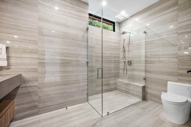 4460 NE 31st Ave, Lighthouse Point, FL 33064 - bathroom featuring a stall shower, toilet, vanity, tile walls, and tile patterned floors