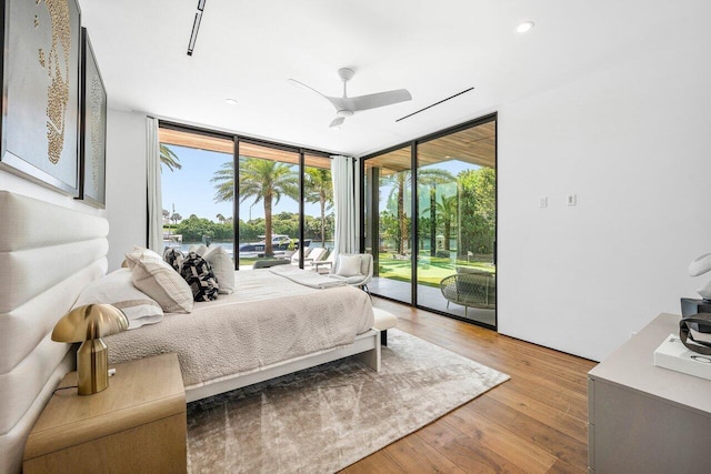 4460 NE 31st Ave, Lighthouse Point, FL 33064 - bedroom with a wall of windows, access to outside, multiple windows, wood finished floors, and ceiling fan
