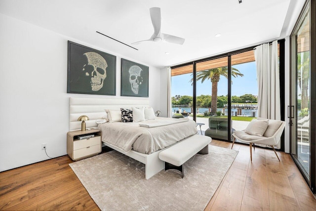 4460 NE 31st Ave, Lighthouse Point, FL 33064 - bedroom with a wall of windows, access to exterior, light wood-style flooring, a water view, and ceiling fan