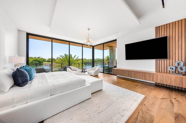 4460 NE 31st Ave, Lighthouse Point, FL 33064 - bedroom with a chandelier, wood finished floors, access to outside, and expansive windows